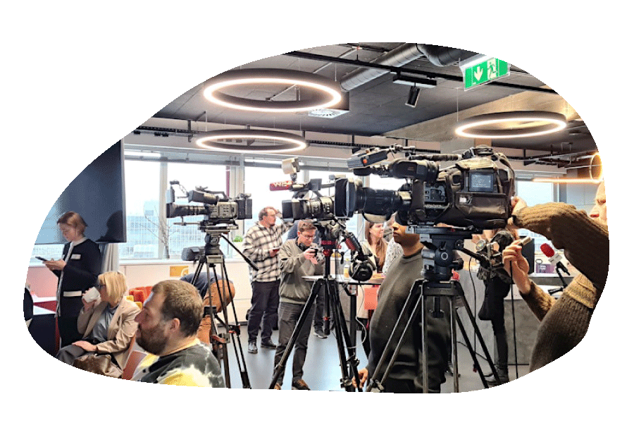 TV cameras and journalists setting up for a press conference