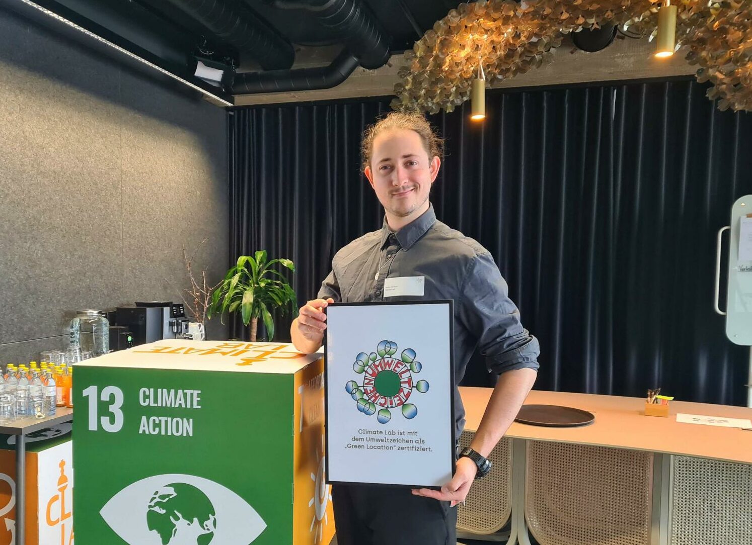 Moritz Hentrich mit unserem Green Location Zertifikat im Climate Lab. Foto: Markus Palzer-Khomenko