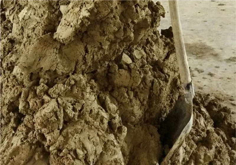 Ein Schaufel in einem Haufe Lehm