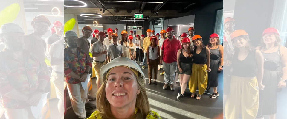 Eine Frau steht mit dem Climate Lab Community im Bauhelme